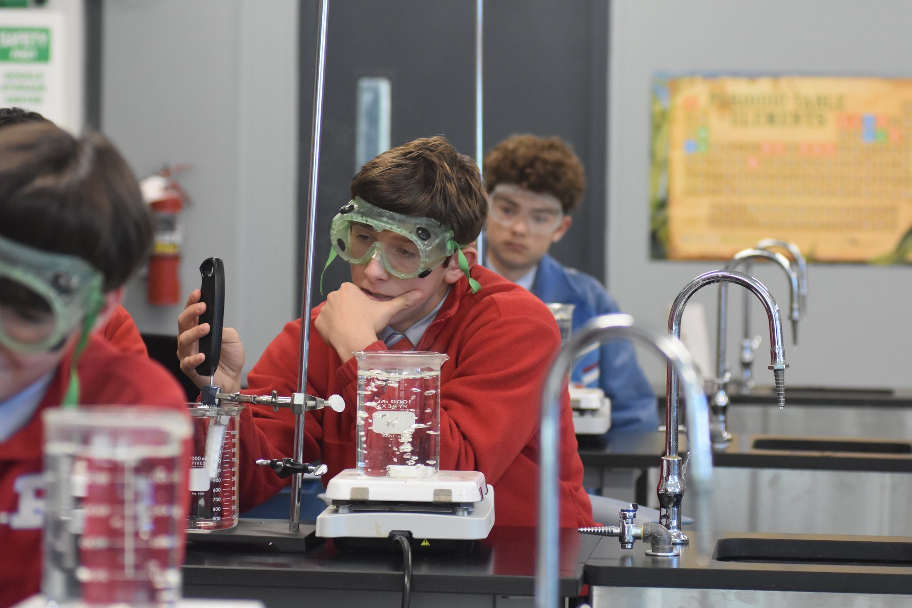Students in goggles at a bench in the chemistry lab