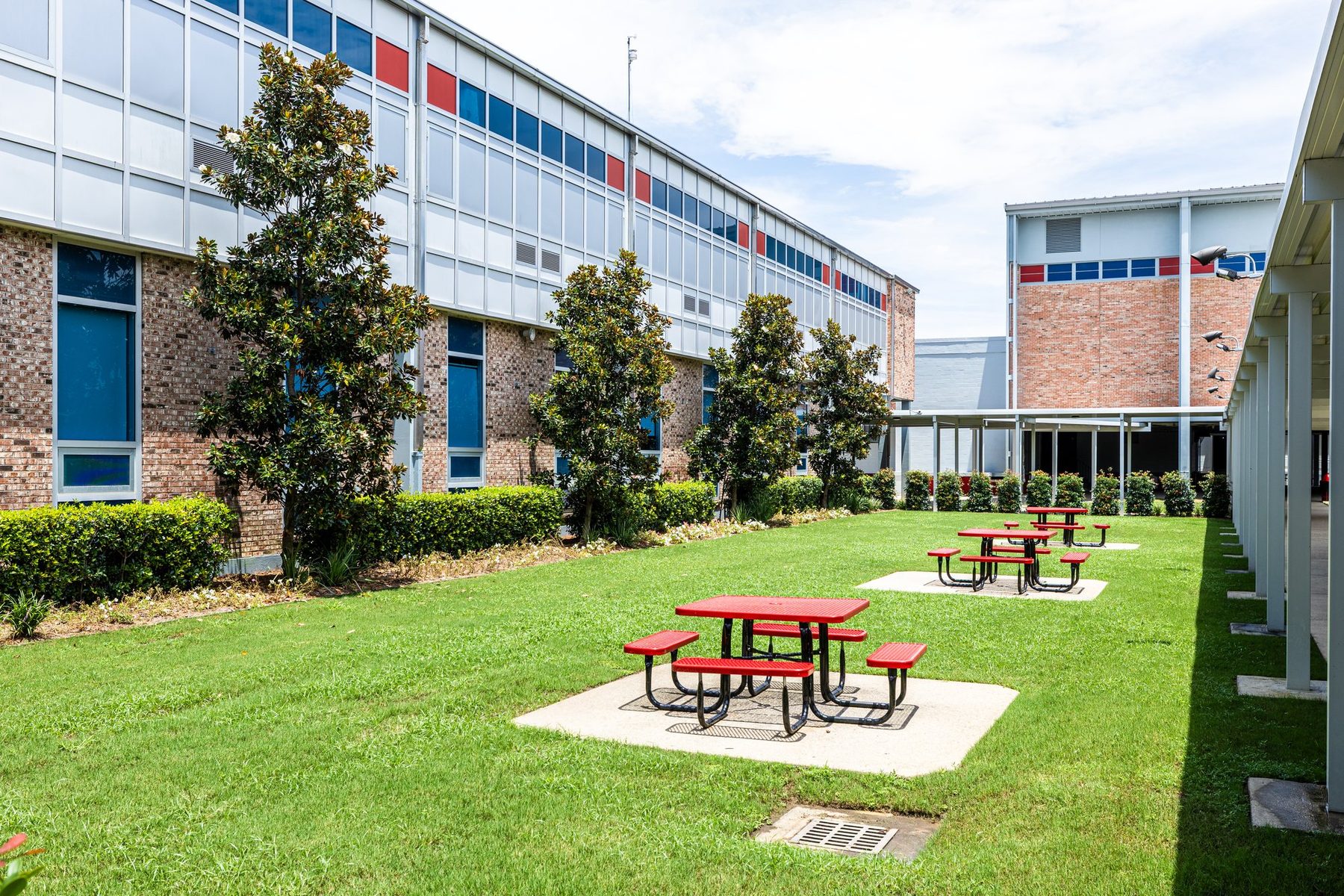 The courtyard between the classroom buildings, grass and red picnic tables