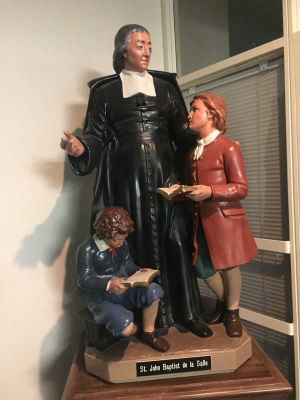 The statue of St. John Baptist de La Salle with two students, at the main entrance