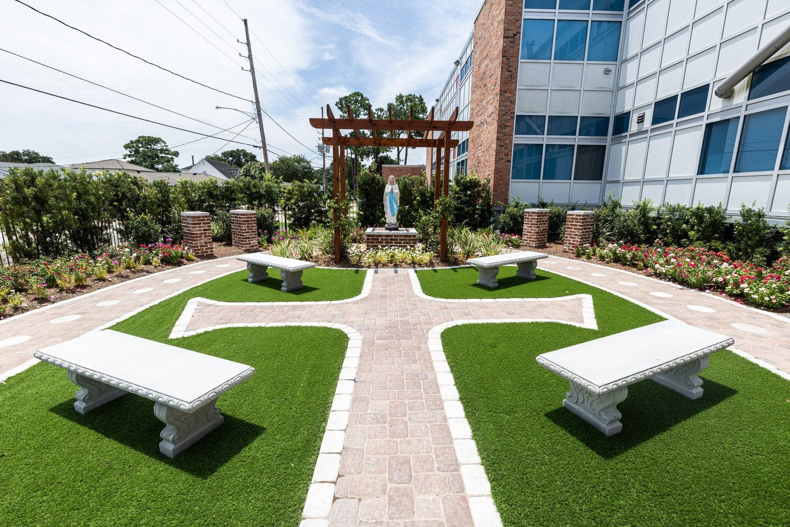 The Rosary and Prayer Garden, its paths laid out as a cross with stone benches and Our Lady beneath a pergola