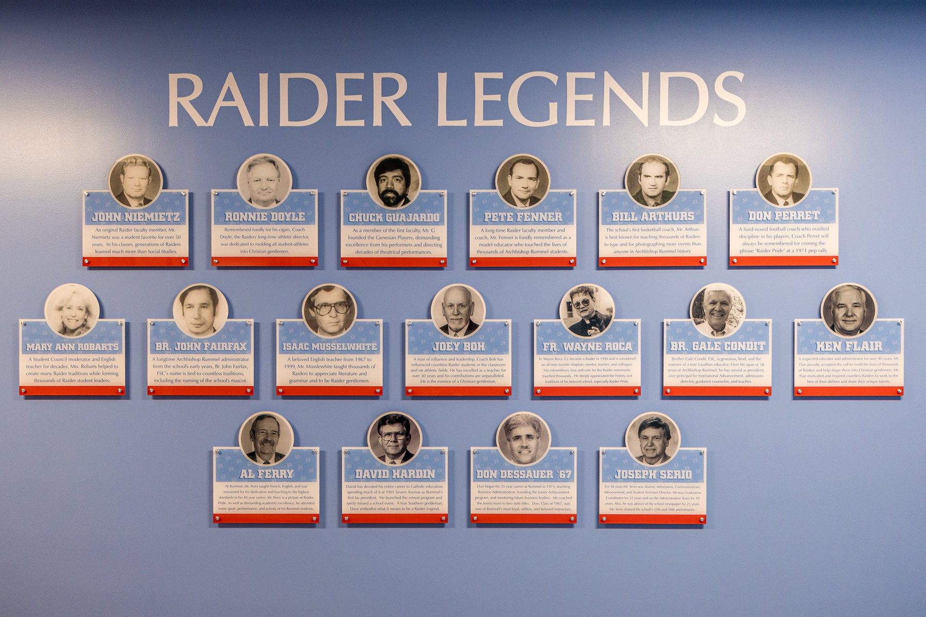 The Raider Legends wall, rows of portrait plaques on a Columbia blue wall