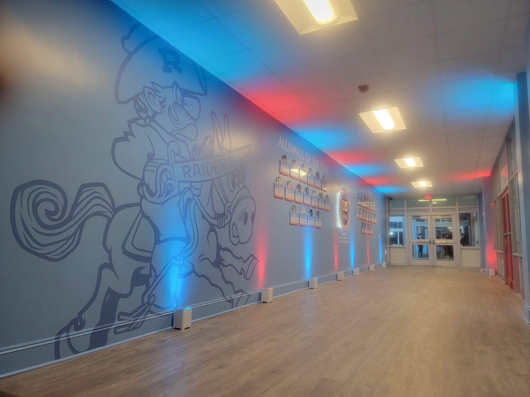 The Raider Room hallway, with the Rufus mural on the wall and the plaques running down the hall