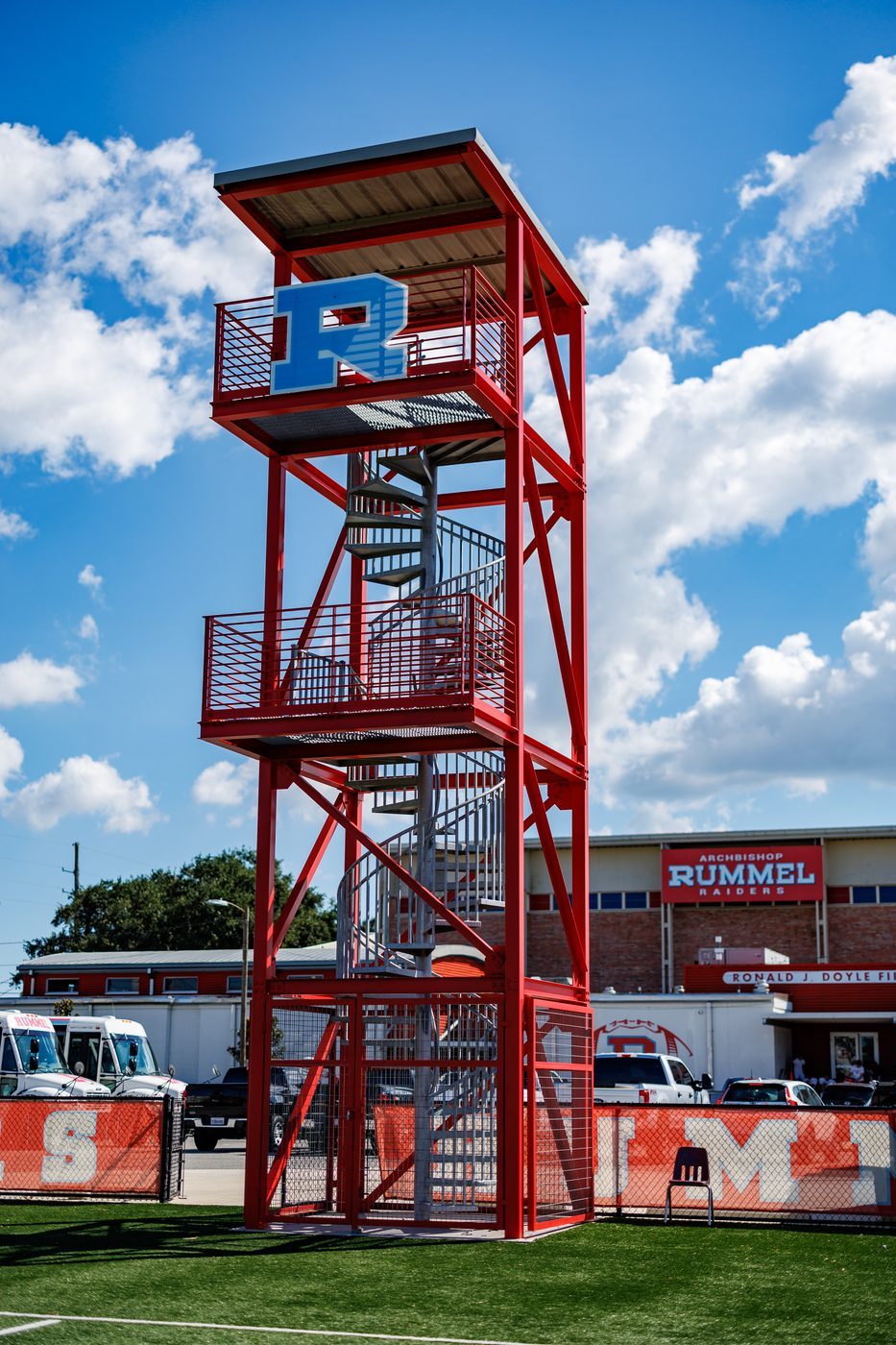The red tower at the end of the field against a blue sky