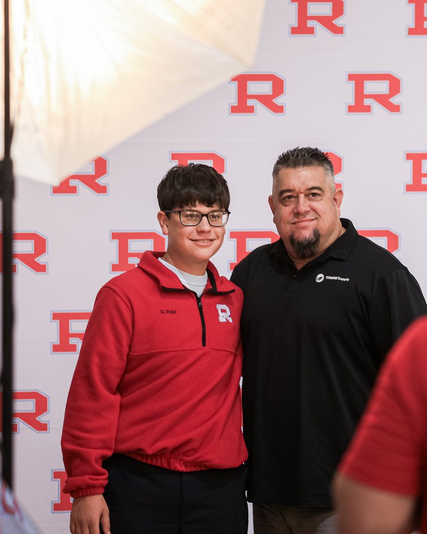 A student and his father photographed in front of the R backdrop