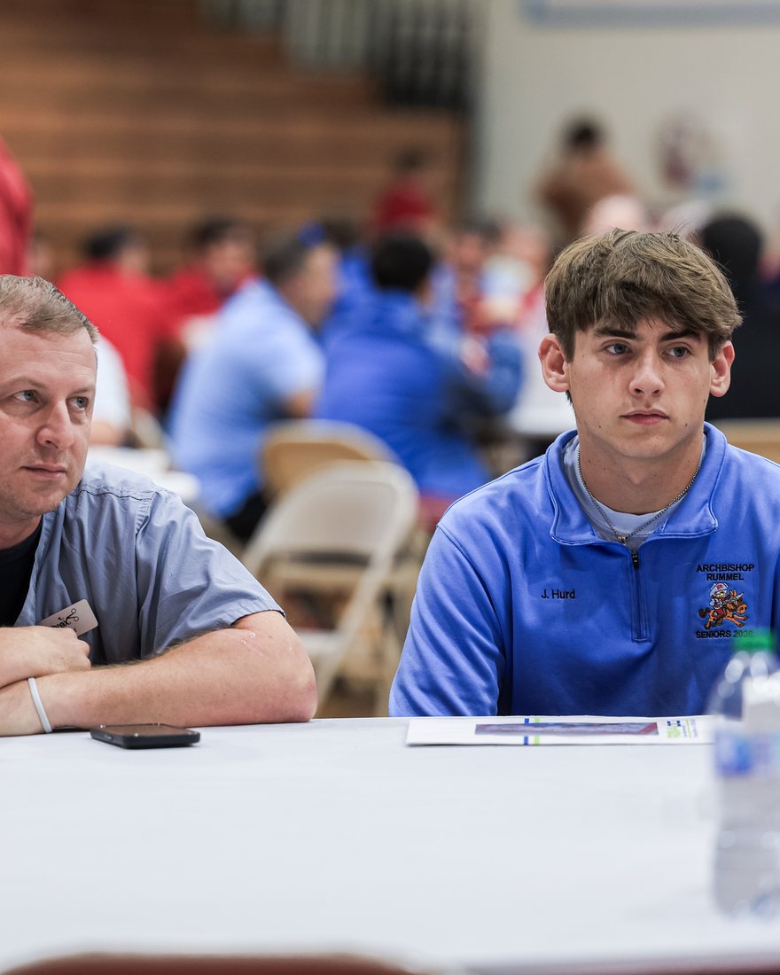 A father and his son at one of the round tables in the gym
