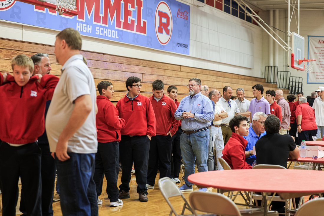 Alumni and their sons gathered under the Rummel High School banner in the gym