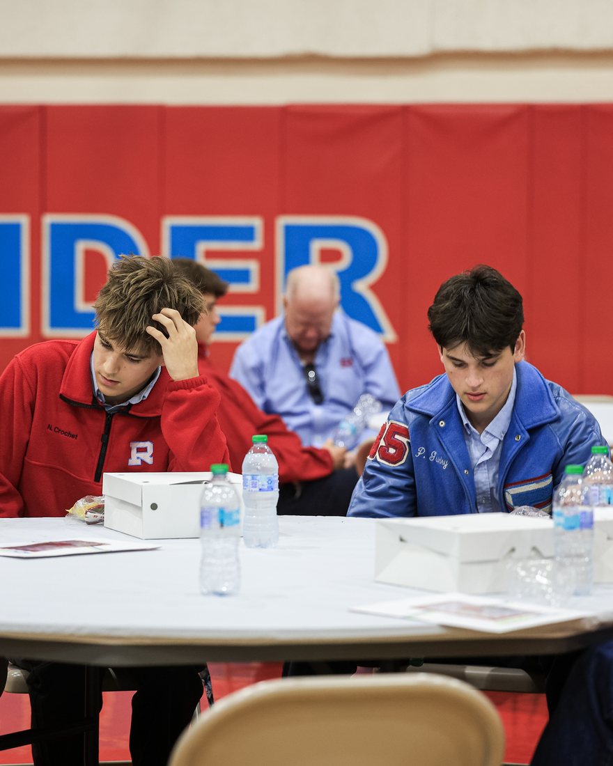 Two students at lunch under the Raiders banner in the gym