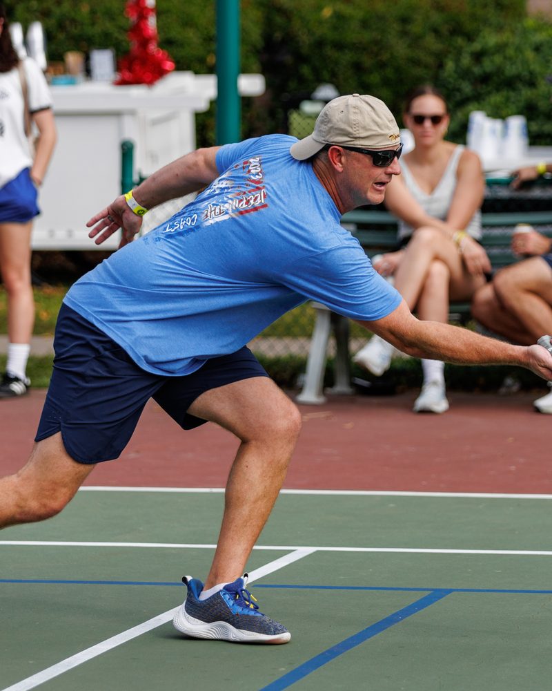 A Raider lunging for a wide ball as spectators watch from the sideline