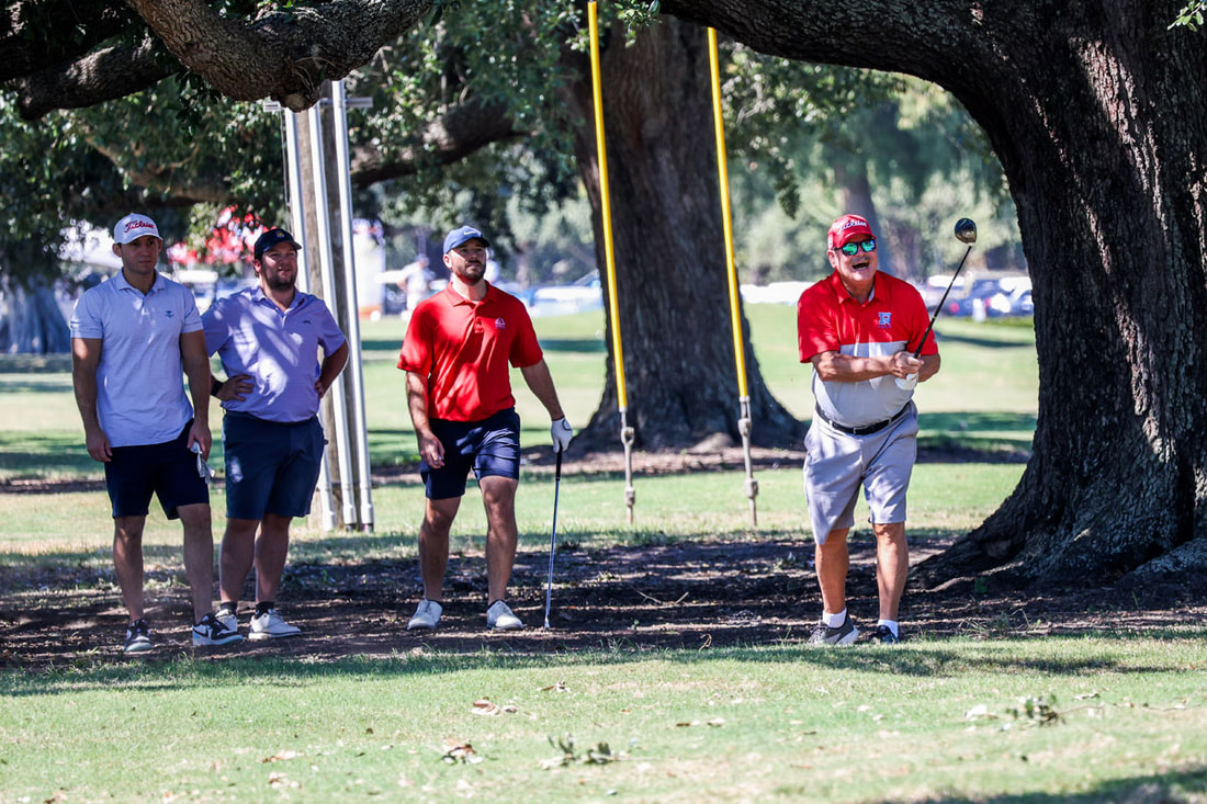 A Raider foursome in red under the live oak on the course