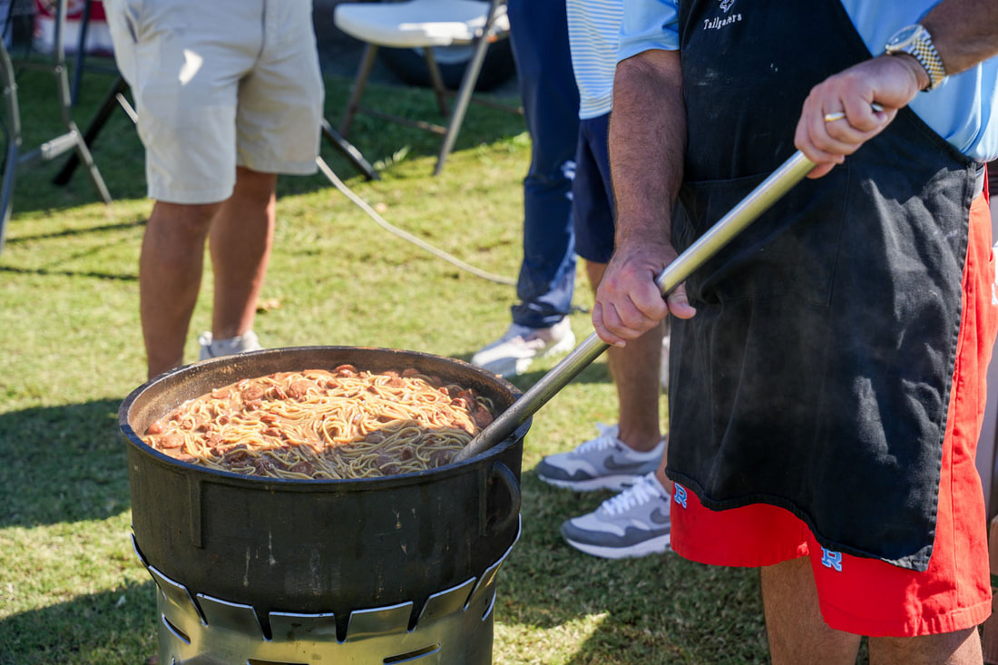 A cast iron pot of jambalaya being stirred at the Raider Classic