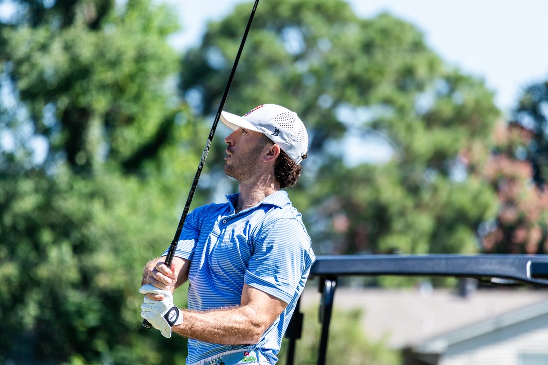 A Raider golfer at the top of his follow through, club overhead