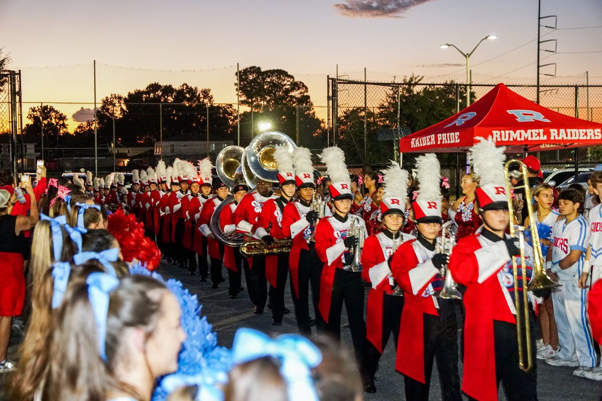 The Raider band stepping off at sunset, pom poms in the foreground