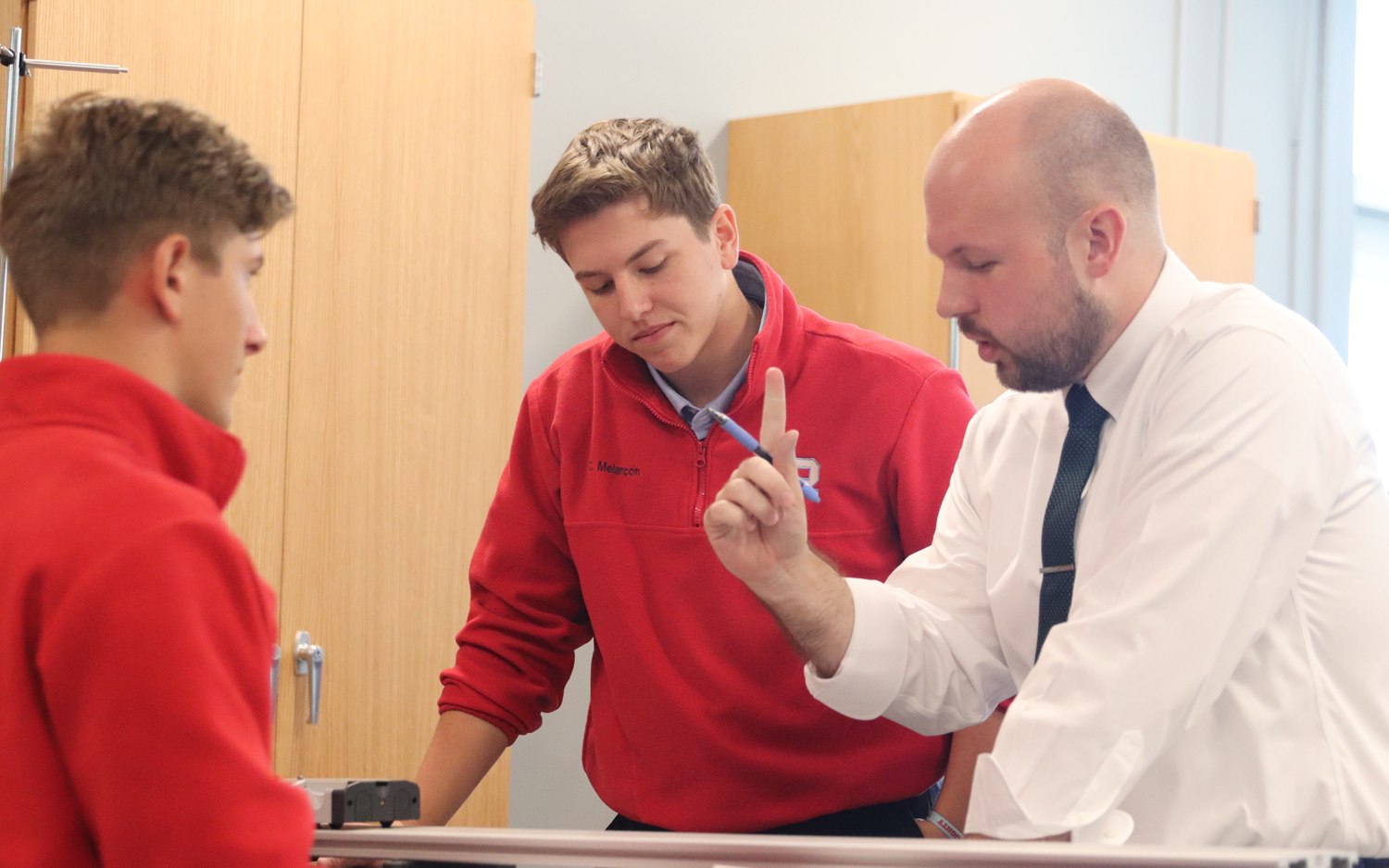 A Rummel teacher working with two students in class