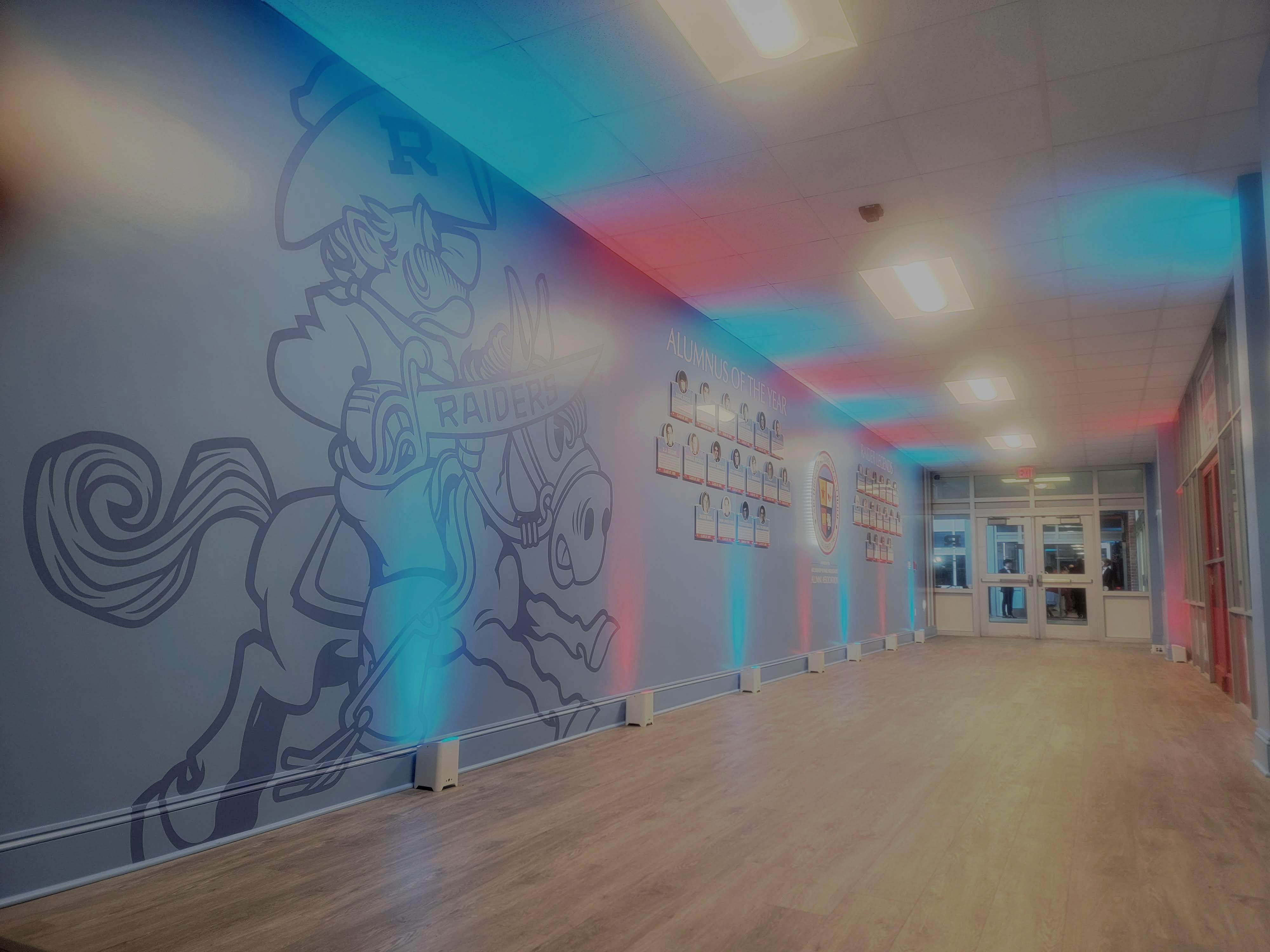 The Raider Room hallway at Archbishop Rummel, washed in red and blue light
